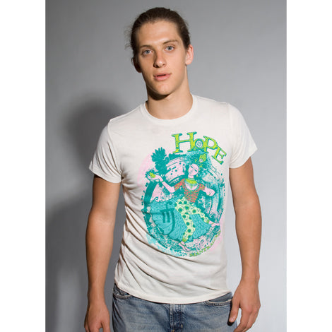 A young man with long hair tied back wears a limited edition Mantralogy white organic cotton t-shirt featuring a colorful abstract HOPE graphic, standing against a plain gray background and looking directly at the camera.