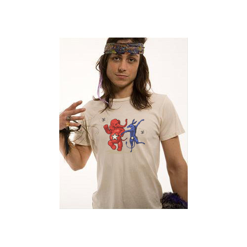 A person with long hair, wearing a floral headband and a Mantralogy organic cotton t-shirt featuring colorful dancing bears, stands against a plain background and gestures with one hand.