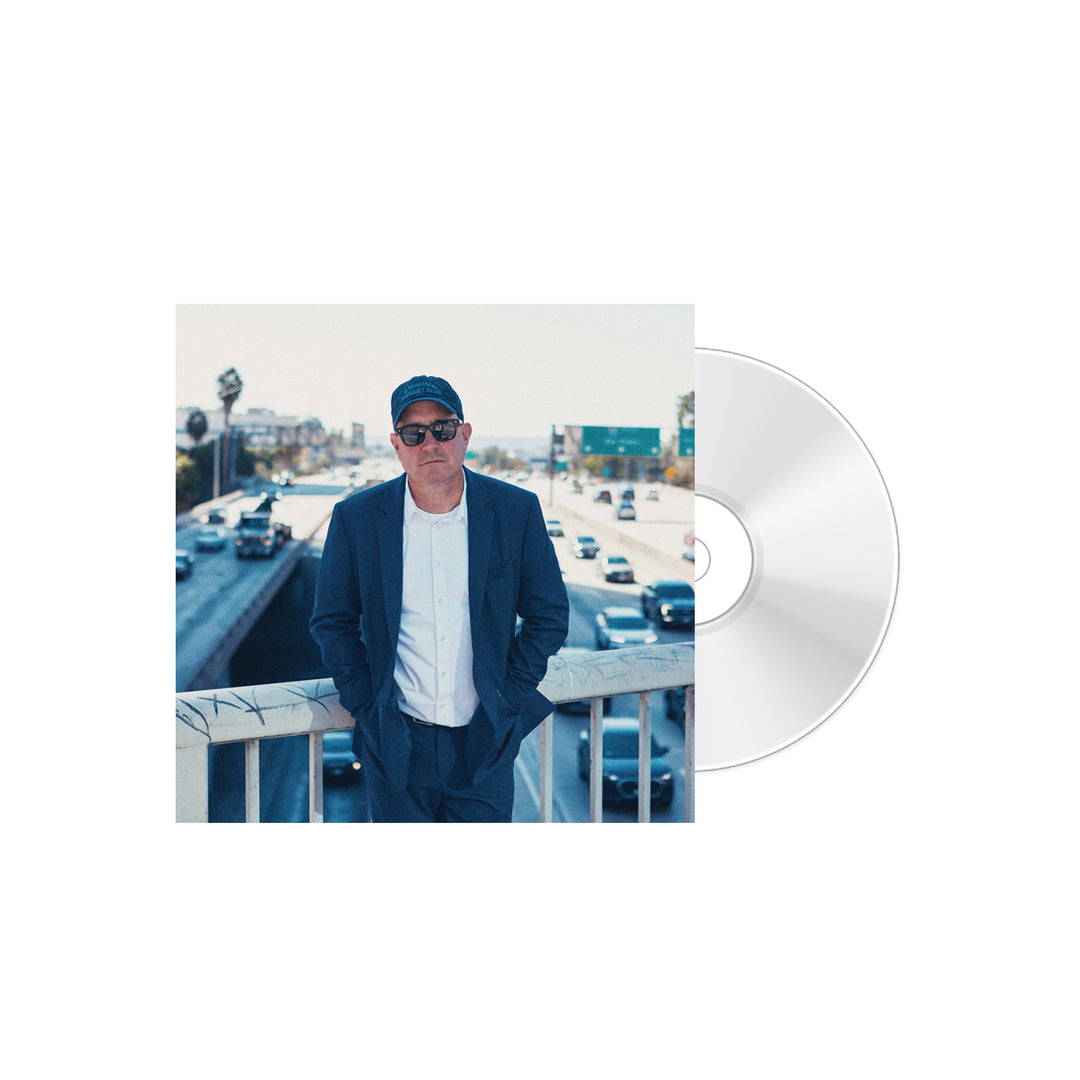 A man in a blue suit and sunglasses stands on an overpass above a busy highway; a clear CD labeled Always Been by the brand Craig Finn partially overlaps the image on a white background.