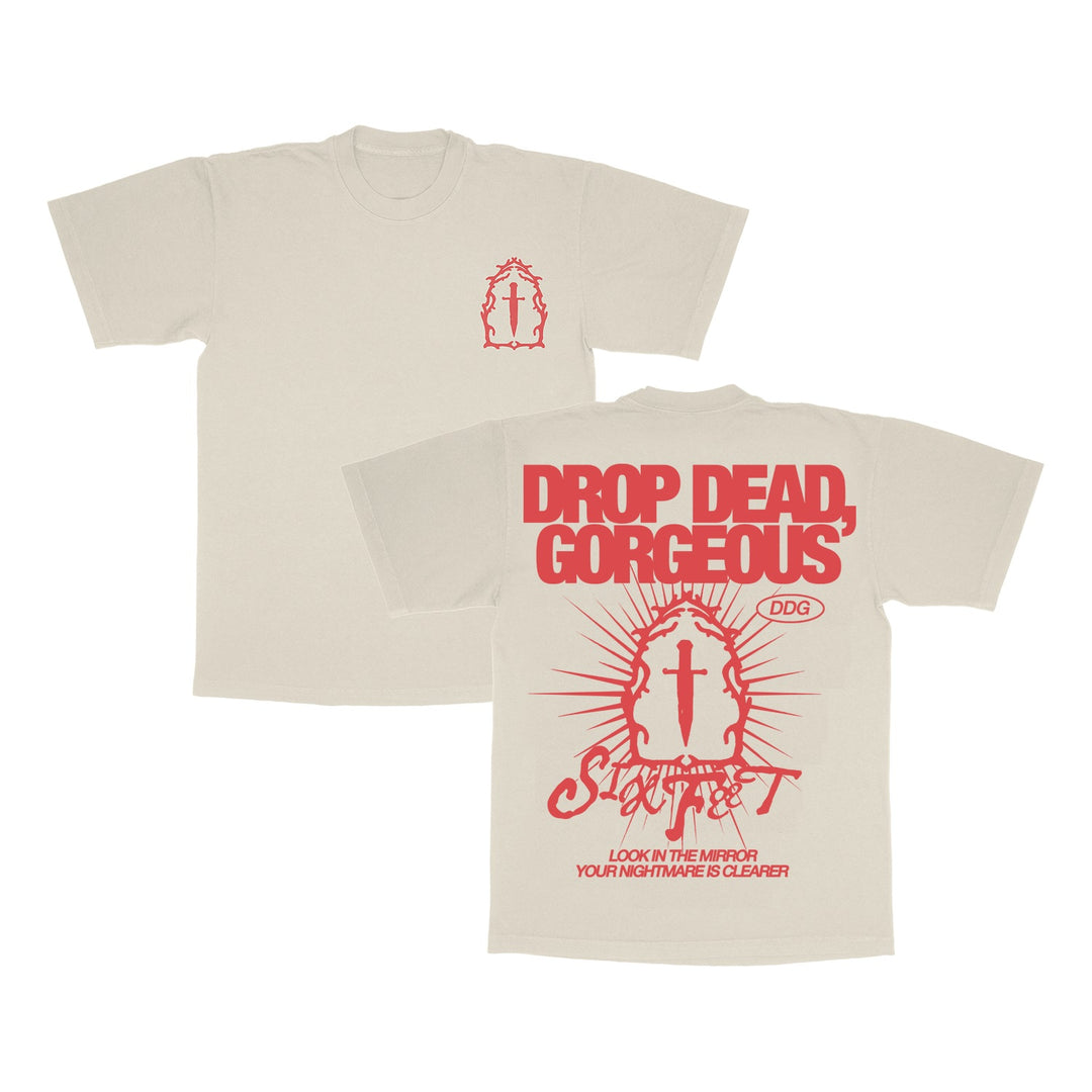 Drop Dead, Gorgeous beige Gildan Softstyle T-shirt in ring-spun cotton (modern classic fit). Red front graphics: small mirror and cross; back has bold DROP DEAD, GORGEOUS text above a large mirror, cross, and additional graphics.