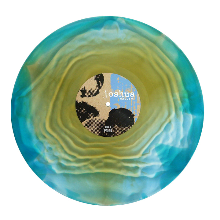 A Joshua vinyl record features a swirling blue, green, and yellow marbled design with a beige and black joshua - ascent center label. Comes in a crystal clear polypropylene sleeve for lasting protection.