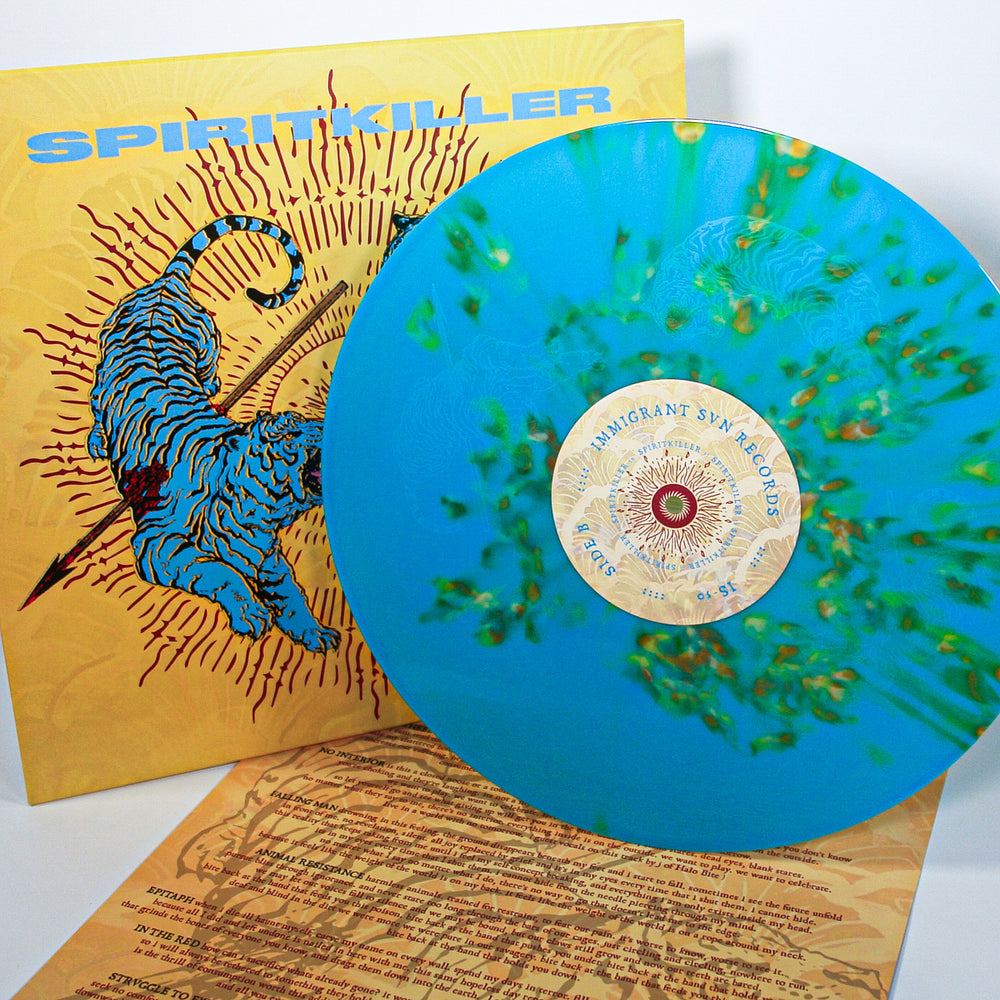 The limited edition blue marbled Spiritkiller vinyl is partially pulled from its yellow cover with a blue tiger and sunburst. In front of the album is a tan lyric sheet with black text.