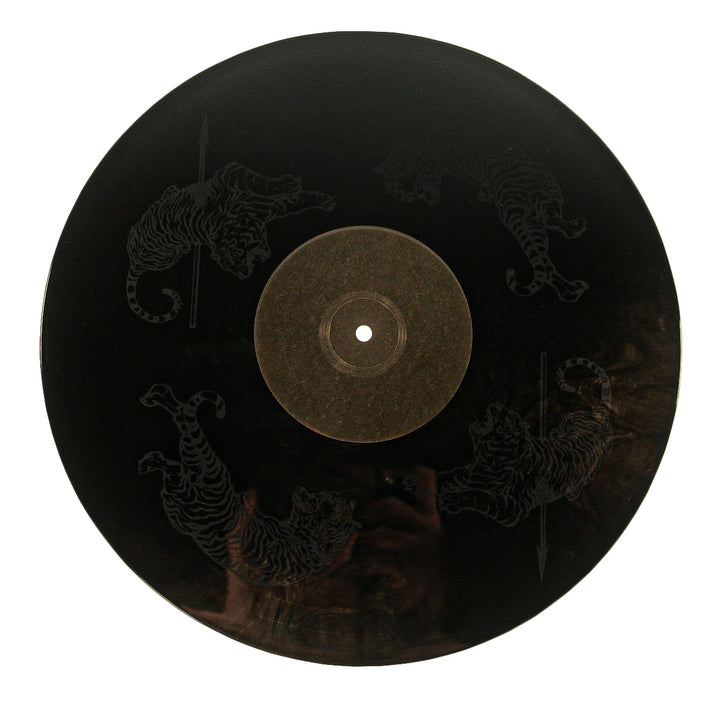 A 12” vinyl from Spiritkiller features etched images of four tigers around the center label, each facing a different direction. The tigers are subtly visible against the dark surface.