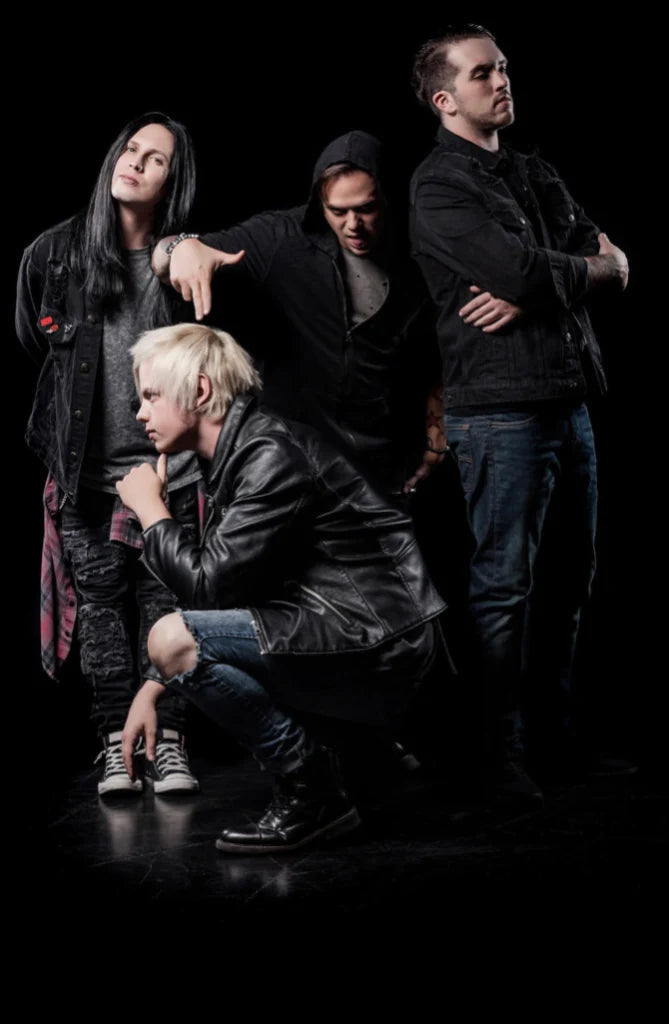 Four young adults dressed in dark, edgy clothing pose confidently against a black background; one squats in front while the others stand behind with serious or expressive looks.