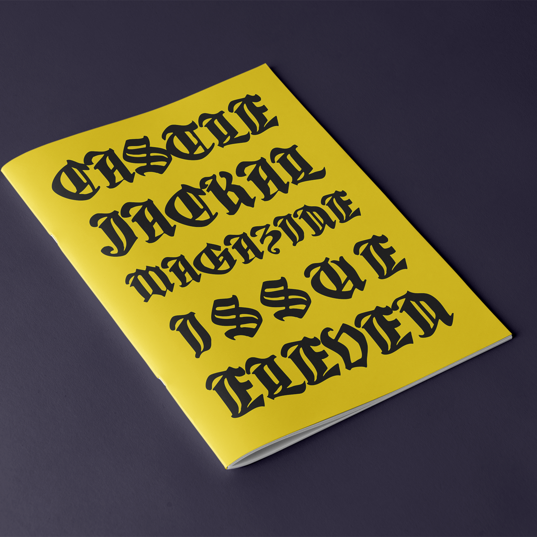 A yellow magazine with bold black Gothic lettering displays "Castle Jackal Magazine Issue Eleven" on the mock cover, set against a dark background.
