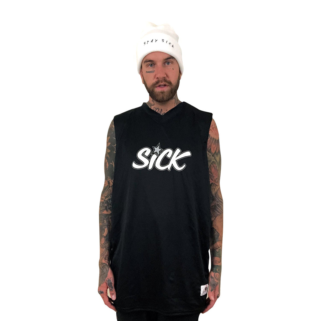 A tattooed, bearded man models edgy streetwear from Stay Sick Clothing: a white beanie with “STAY SICK” and a sleeveless black tee with “SICK” in bold on the front, all set against a plain white background.
