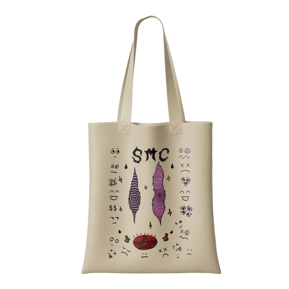 Beige reusable shopping bag by Strawberry Milk Cult, featuring abstract black and purple illustrations—swirled cones, eyes, faces, and "SMC" lettering at the top center.