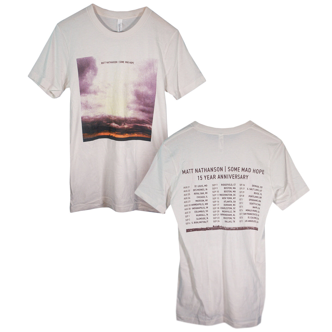 Two white Matt Nathanson T-shirts feature a cloudy sunset photo and But Somehow I Knew Wed Be on the front, with cities and dates for the Some Mad Hope 15 Year Anniversary tour on the back.