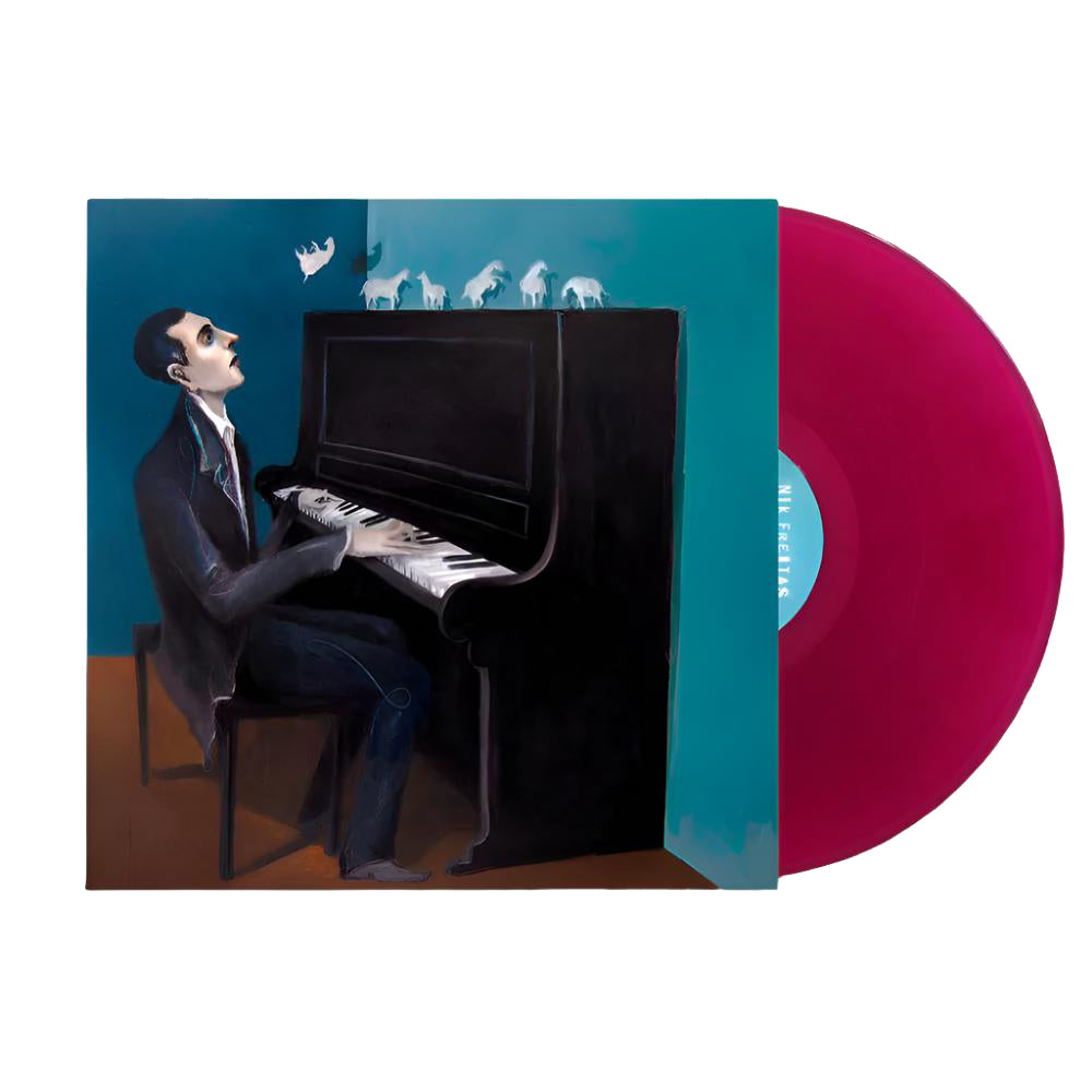 A vinyl record with magenta coloring, placed beside its cover, which displays a surreal painting of a man in a suit playing piano—small white animals and abstract shapes float above the keys, capturing the dreamlike atmosphere of Cabrillo Island—a release by Nik Freitas.