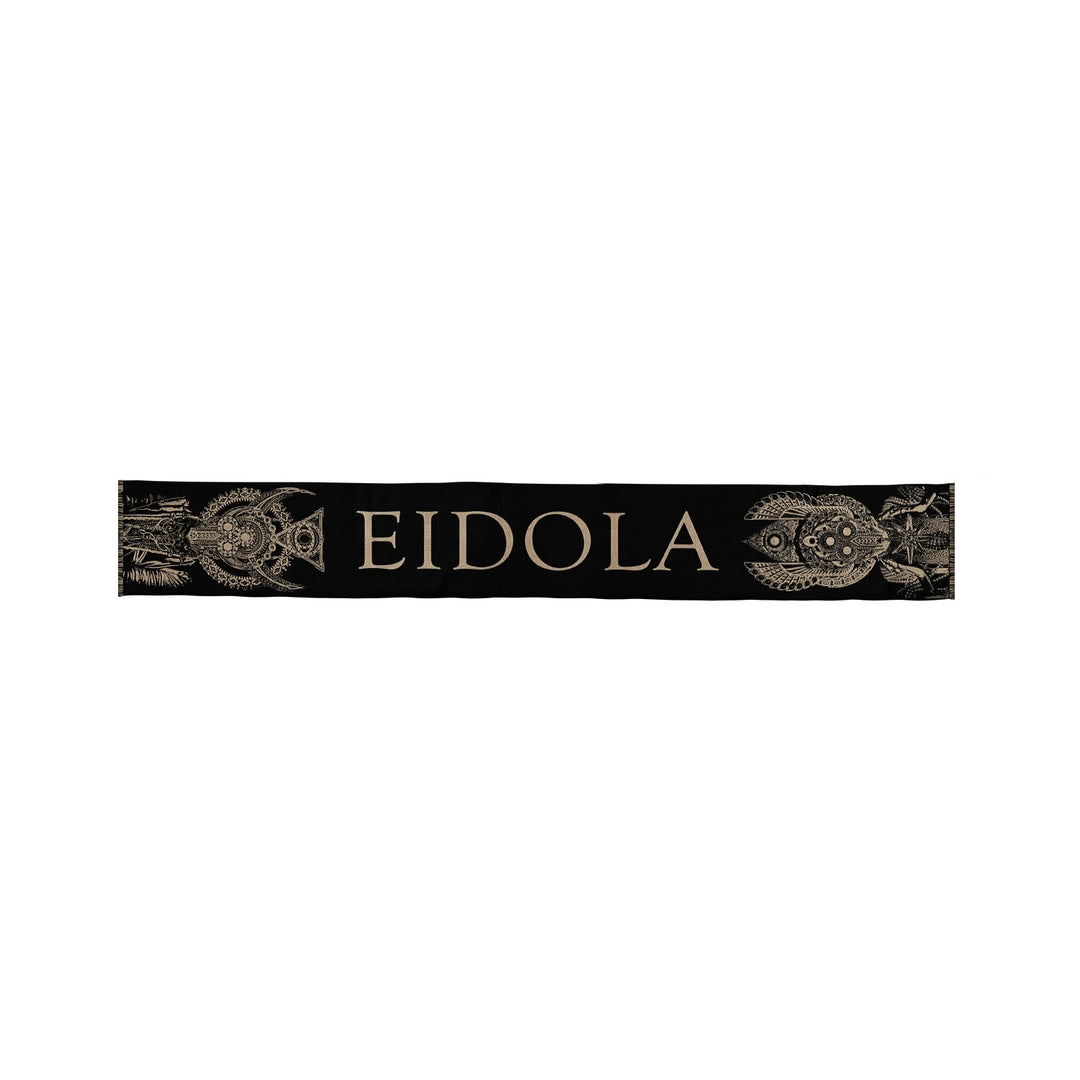 A black rectangular Eidola scarf featuring large light-colored "EIDOLA" lettering, accented with ornate fish illustrations at each end.