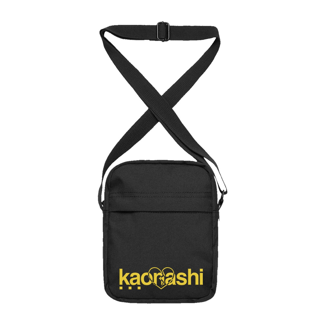 A compact black Kaonashi side bag with an adjustable strap, featuring bold yellow "Kaonashi" lettering and a heart outline on the front—perfect as a stylish crossbody for your everyday essentials.