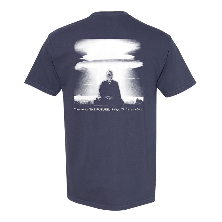 This Die Young Comfort Colors tee showcases a navy design with a white graphic of a suited man before a nuclear blast. Bold text reads: I’ve seen THE FUTURE, baby. It is murder.