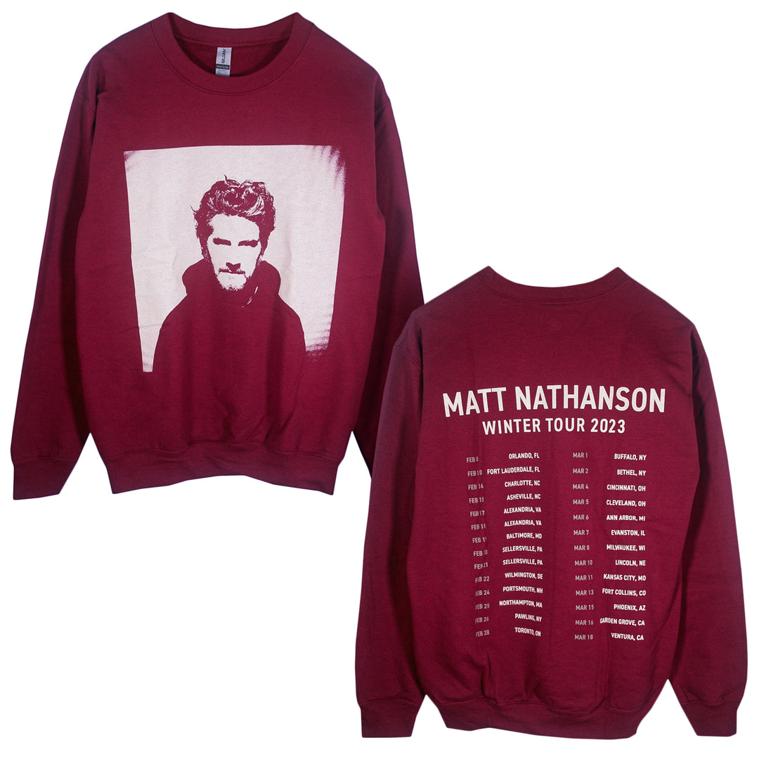A maroon Matt Nathanson Heavy Blend crewneck sweatshirt from the Winter Tour 2023, featuring a black-and-white front portrait and tour dates with cities listed under the artist’s name on the back.
