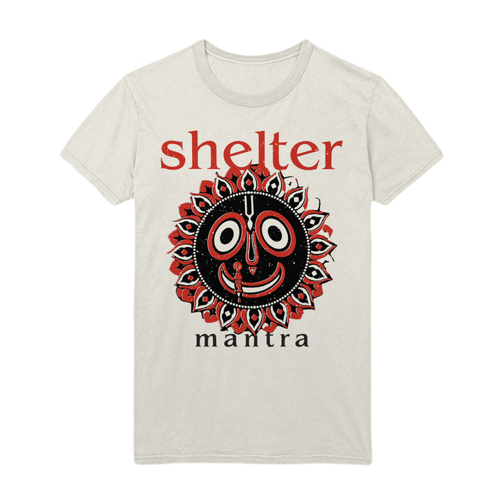A natural Shelter t-shirt showcases a stylized black and red sun-like face graphic, with "Shelter" in bold red text above and "mantra" in black below the design.