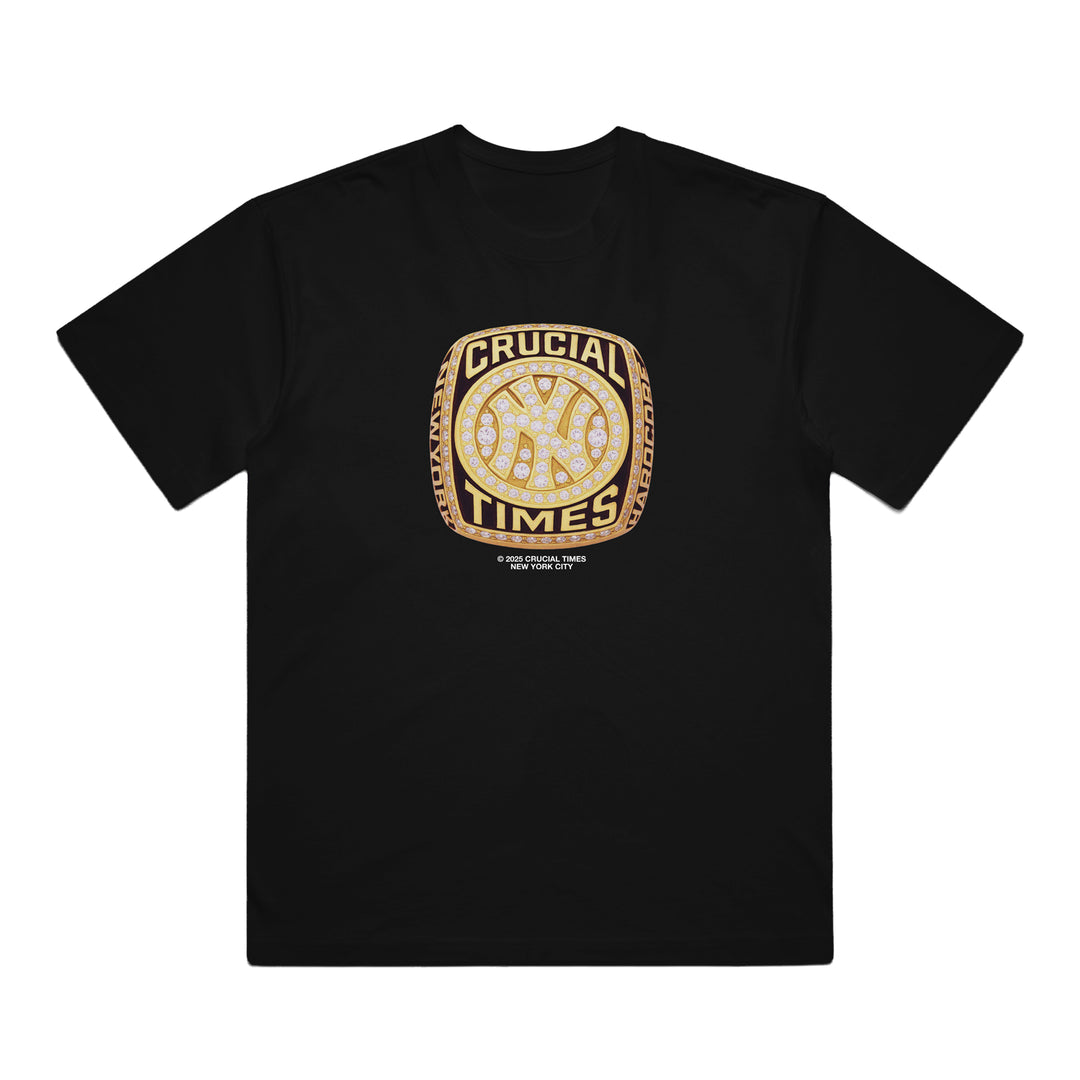 Crucial Times black Comfort Colors t-shirt with a bold gold and diamond championship ring graphic, "CRUCIAL TIMES" text around a baseball icon, and fine print below. Perfect collectible apparel for true champions.