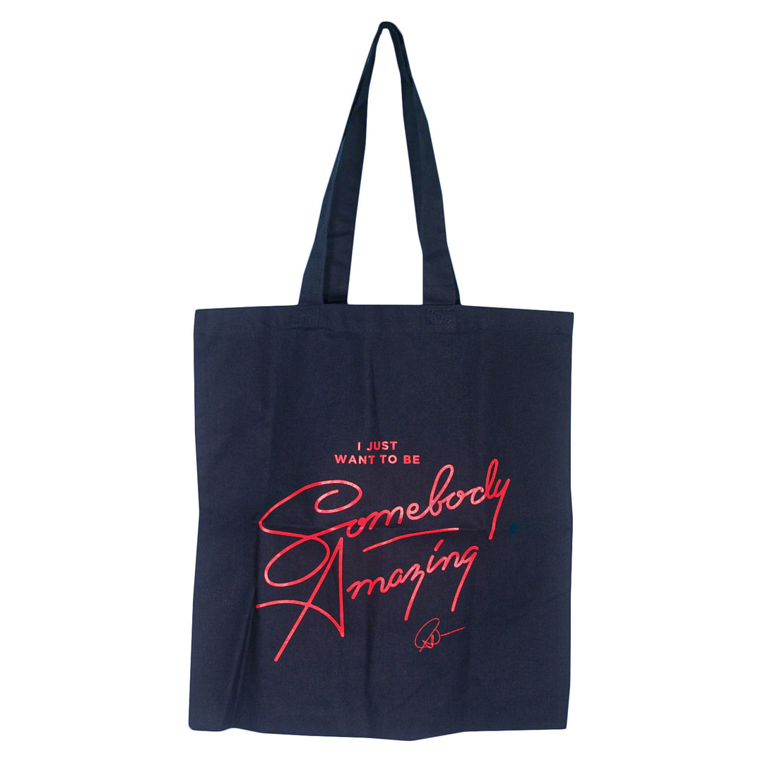 A navy blue Matt Nathanson tote bag with red script reading “I just want to be Somebody Amazing” and a small signature at the bottom—perfect for exploring the city in style.