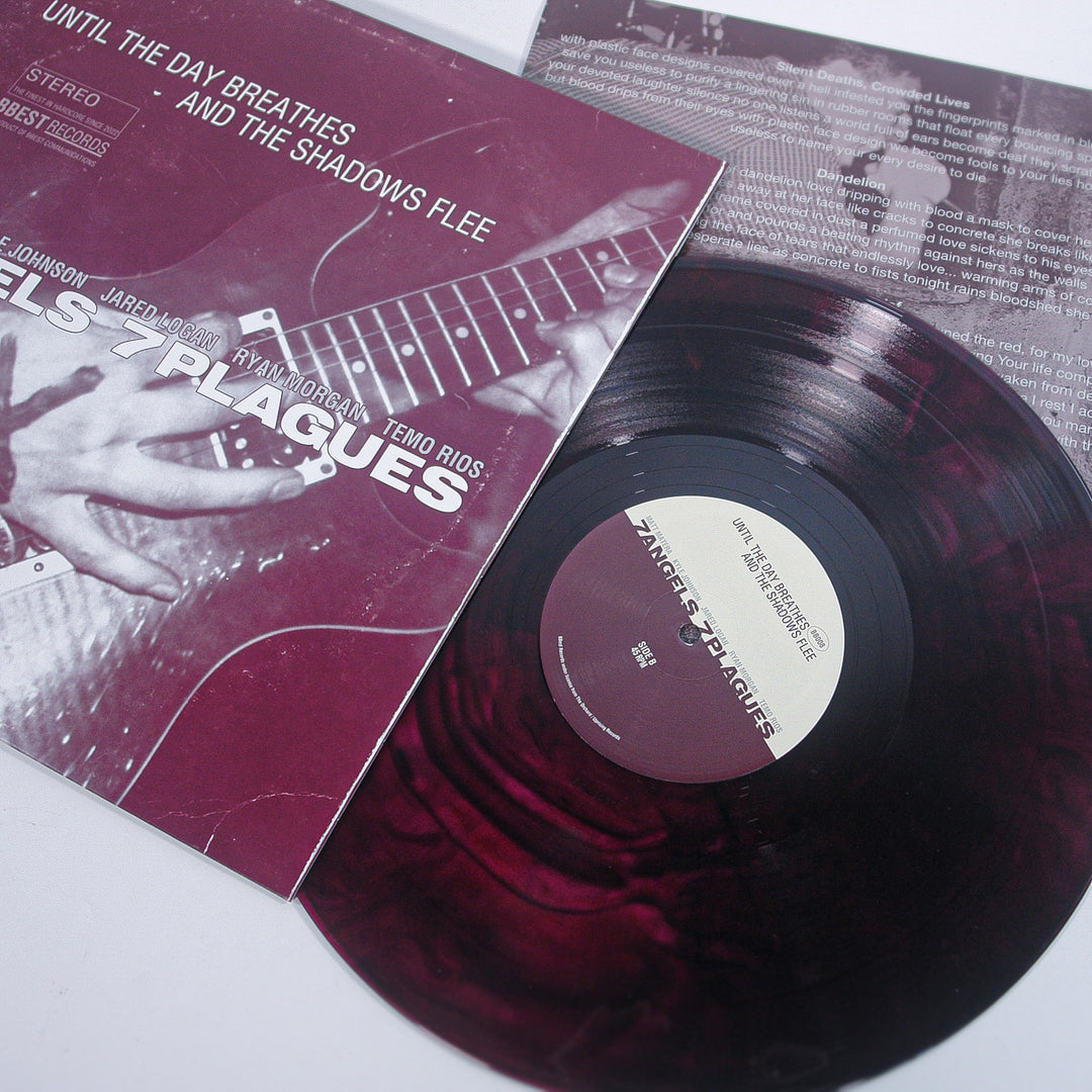 A marbled burgundy swirl smoke vinyl by 7 Angels 7 Plagues is partially pulled from its sleeve, showing a close-up of a guitarist’s hands and the title Until the Day Breathes and the Shadows Flee.