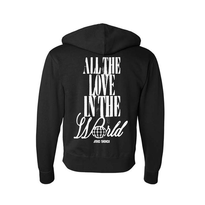 A black zip-up hoodie by MC YOGI featuring white "ALL THE LOVE IN THE WORLD" text above a small globe and "MC YOGI" on the back.
