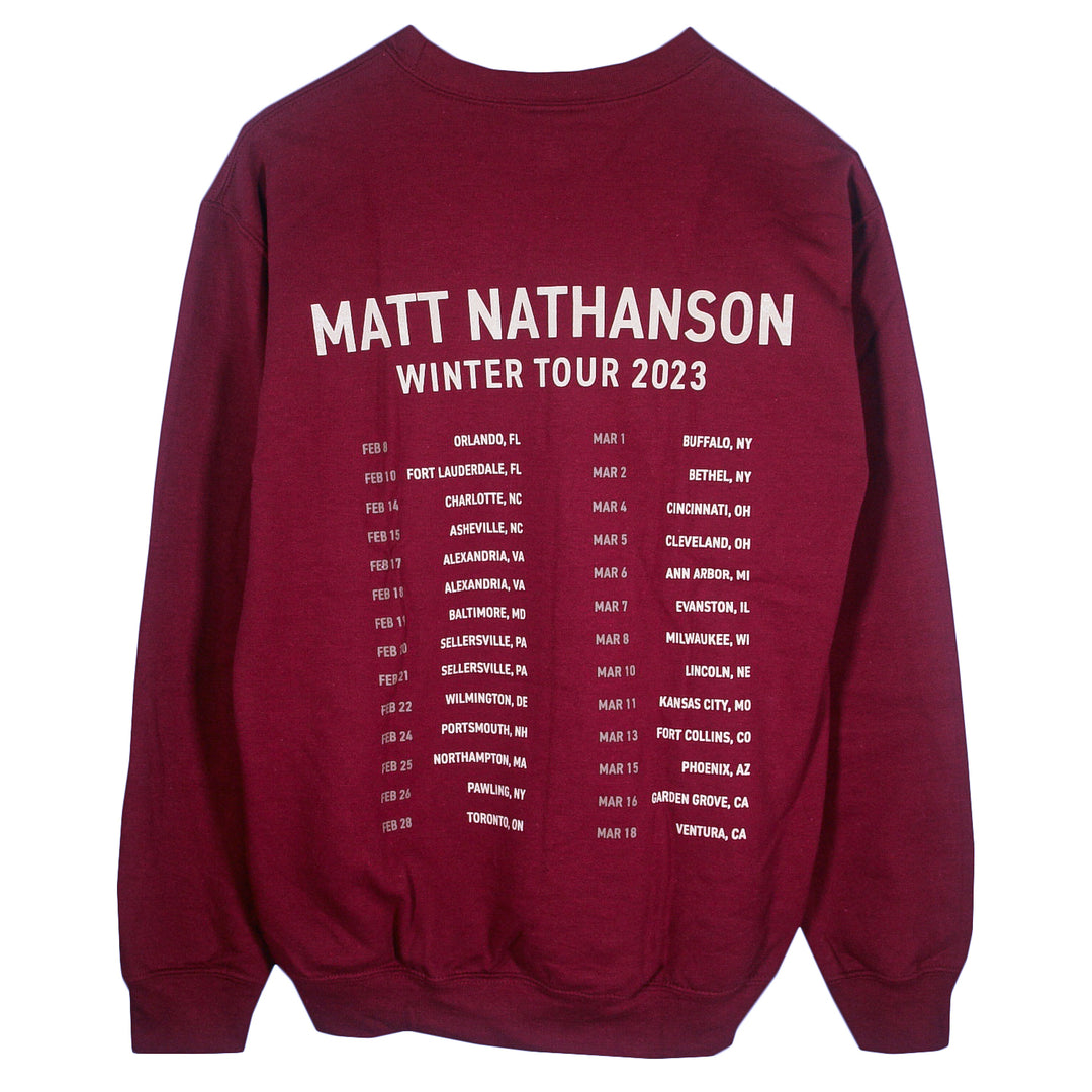 A maroon Matt Nathanson crewneck sweatshirt featuring Winter Tour 2023 in white on the back, plus tour dates and cities from the US and Canada.