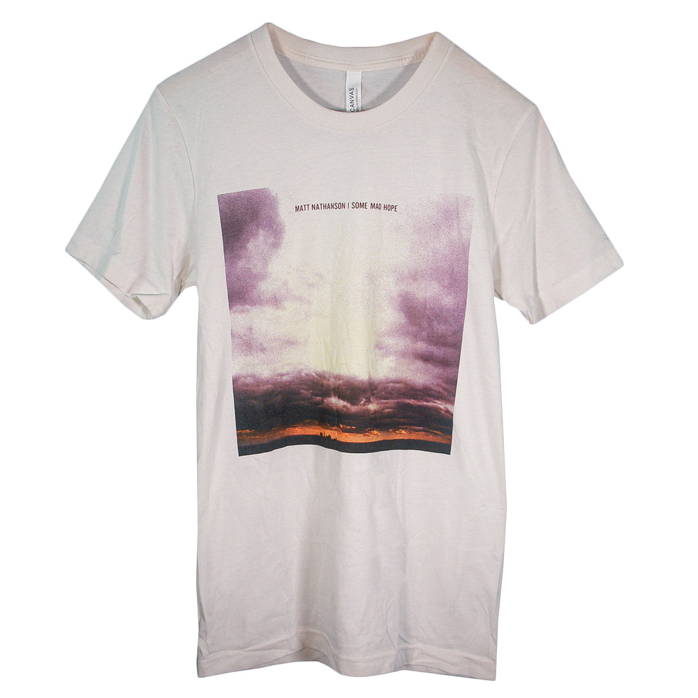 A Matt Nathanson white T-shirt with a rectangular print of a purple and orange cloudy sunset sky and “MATT NATHANSON SOME MAD HOPE” in small text above the image.