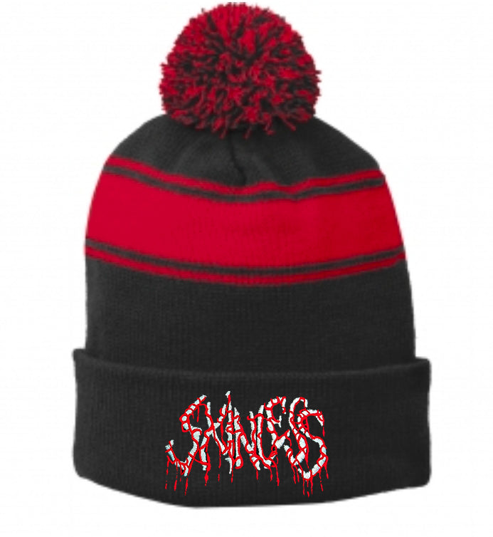A Skinless Sport-Tek black pom-pom beanie with a red stripe and red-black pom. "SHACKS" is embroidered on the front fold in a white candy-cane style logo with red accents.