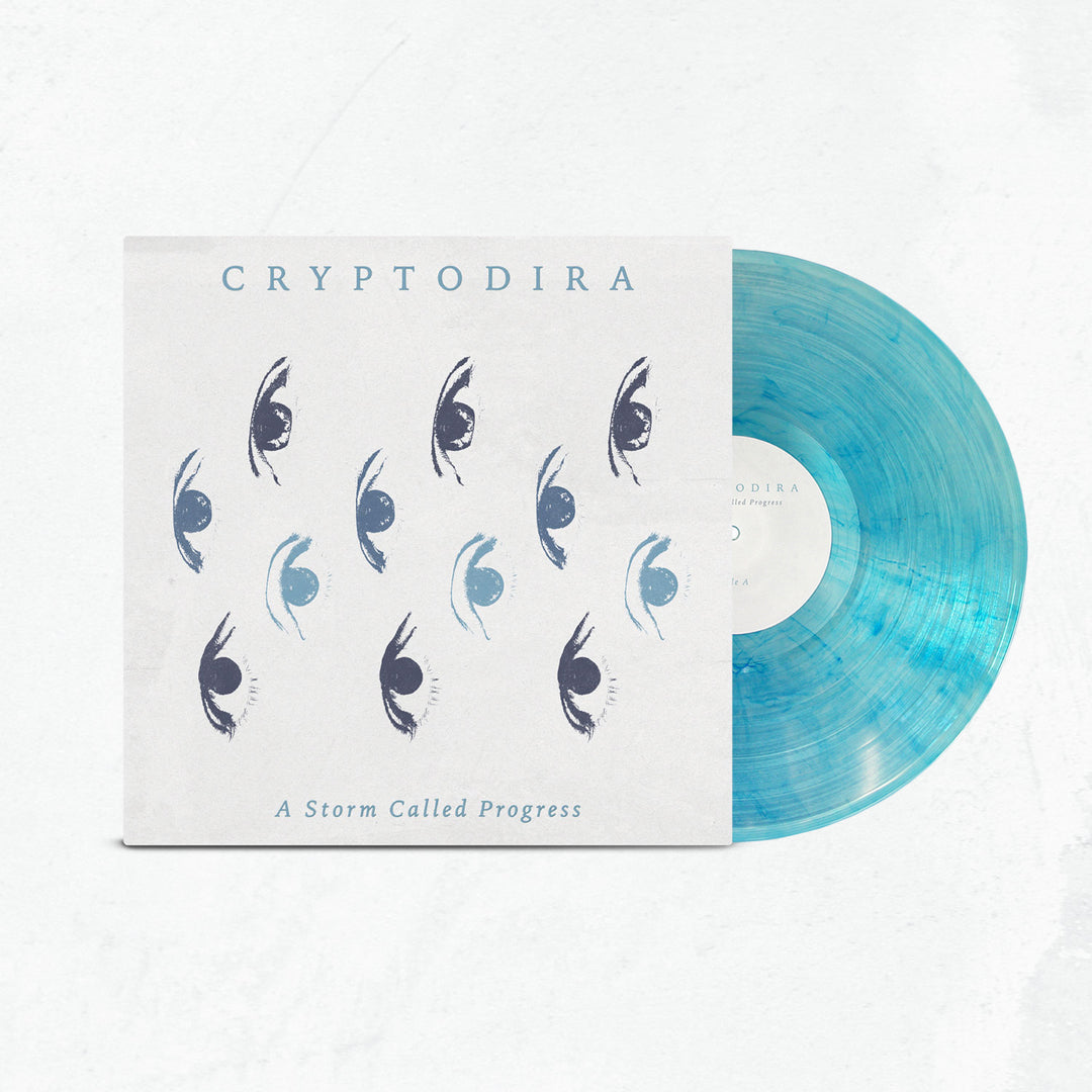 A limited edition light blue marbled vinyl, partially in its sleeve, displays Cryptodira’s name, abstract eye graphics, and the album title "A Storm Called Progress" on a white background.