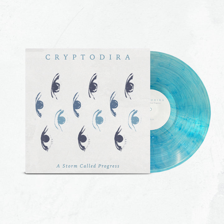 A limited edition light blue marbled vinyl, partially in its sleeve, displays Cryptodira’s name, abstract eye graphics, and the album title "A Storm Called Progress" on a white background.