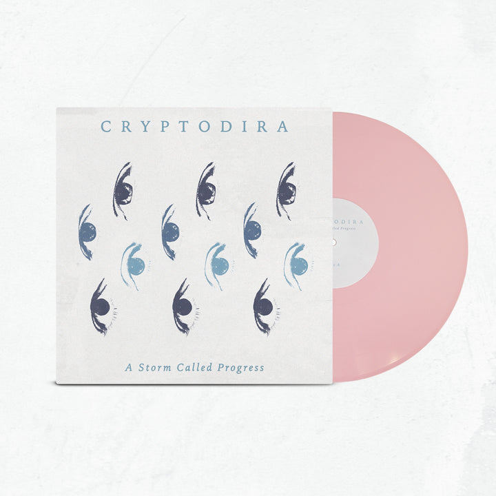 A limited edition light pink vinyl slides out of a cover featuring blue and black stylized eye art. The cover displays Cryptodira at the top and A Storm Called Progress at the bottom.