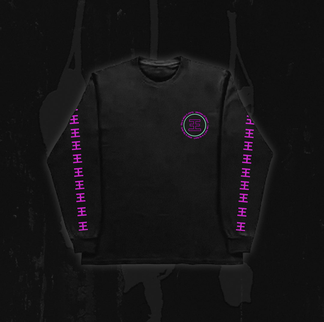 A black long-sleeve shirt from Reflections, featuring a pink geometric Crystal Eyes logo on the chest and repeating pink symbols down both sleeves, displayed against a dark background.