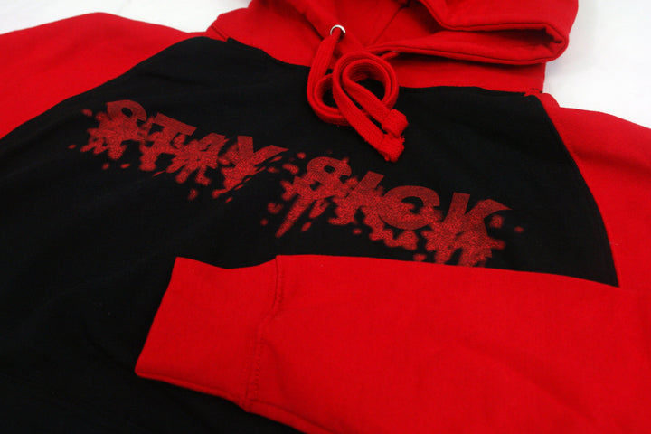 Stay Sick Clothing’s red and black raglan hoodie features bold red sleeves, a black body, and “STAY SICK” in a dripping graffiti font across the chest for standout style.