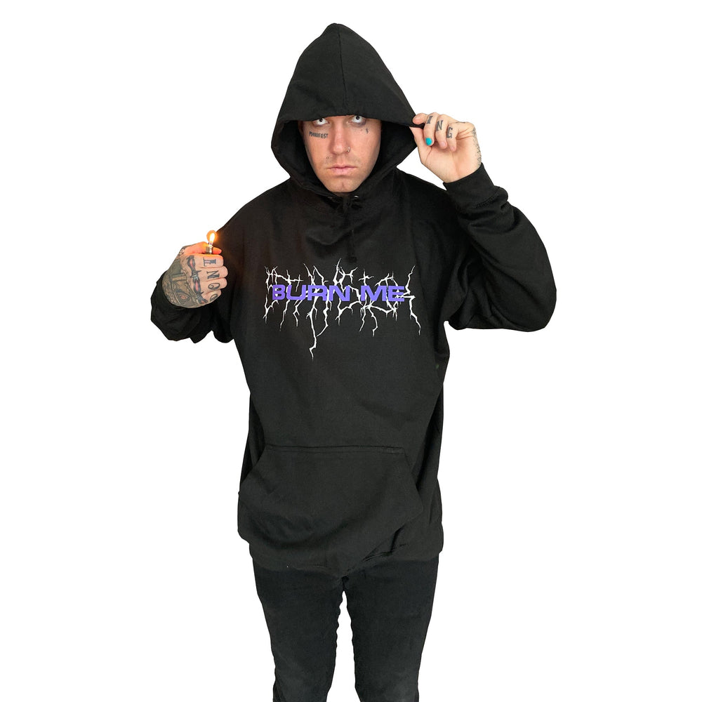 A person wearing a Stay Sick Clothing black hoodie featuring a lightning design and Burn Me Black text holds a lit lighter and lifts the hood, standing against a plain white background.