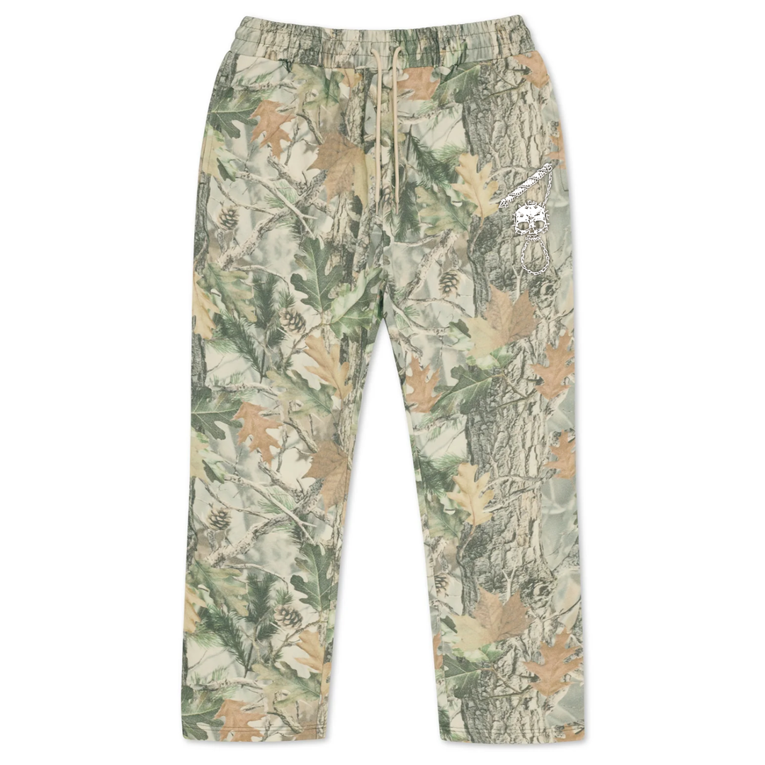 Vintage wood camo sweatpants in a forest camouflage print with a small white embroidered skull graphic on the right thigh.