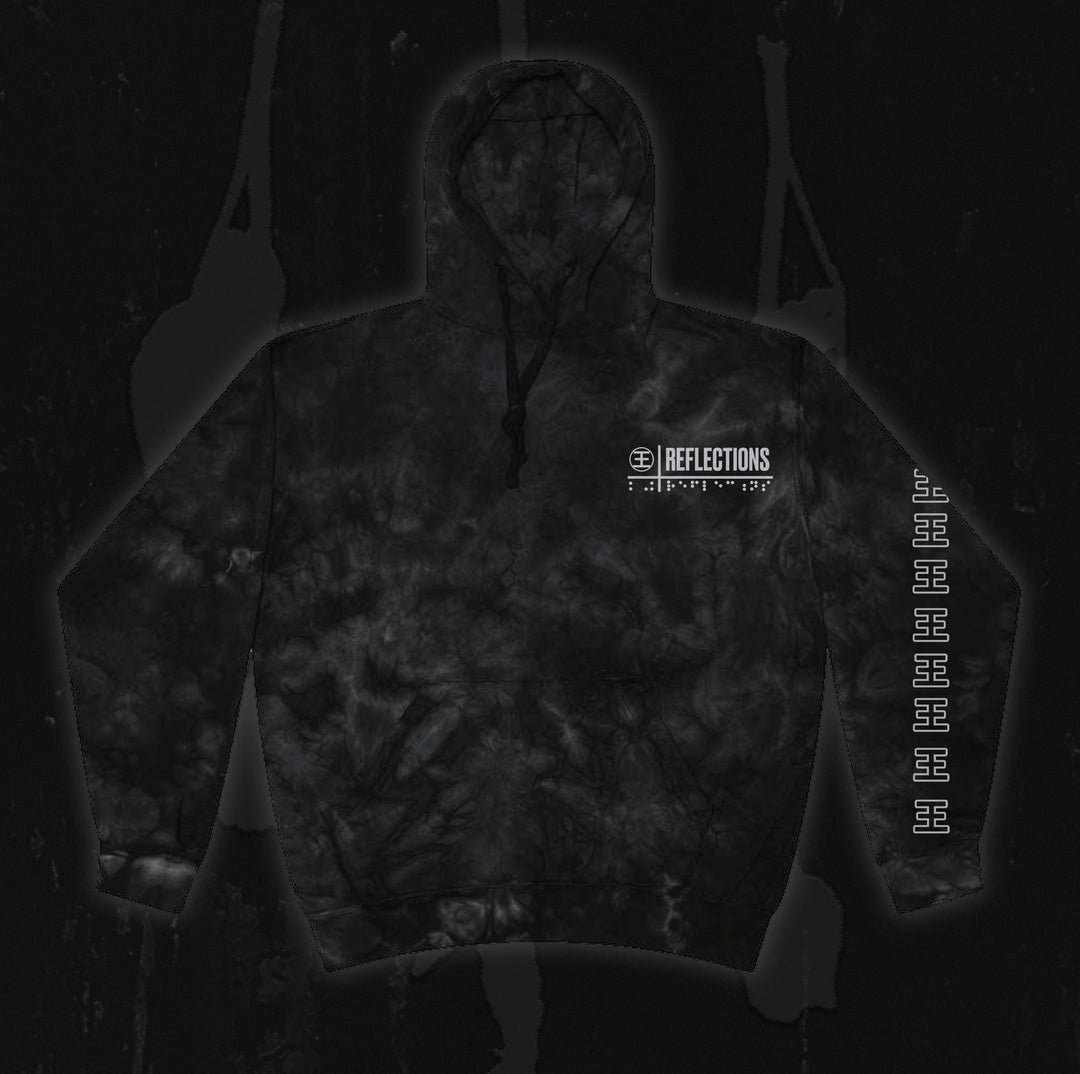 Certainly! Here’s the revised sentence using your product data: A black tie-dye hoodie from Reflections with the brand name and logo on the chest, featuring repeated white symbols down one sleeve—perfect for fans of Crystal Eyes or collectors of exclusive instrumental digital downloads, displayed on a dark background.