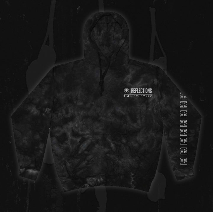 Certainly! Here’s the revised sentence using your product data: A black tie-dye hoodie from Reflections with the brand name and logo on the chest, featuring repeated white symbols down one sleeve—perfect for fans of Crystal Eyes or collectors of exclusive instrumental digital downloads, displayed on a dark background.