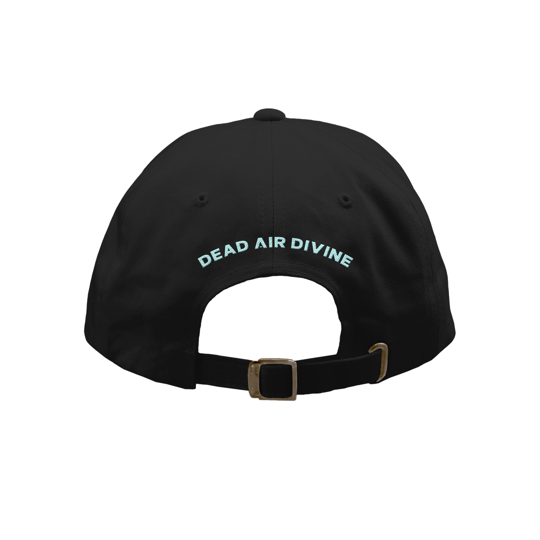 A black Dead Air Divine baseball cap is seen from the back, featuring "DEAD AIR DIVINE" in light blue above an adjustable strap with a metal clasp.