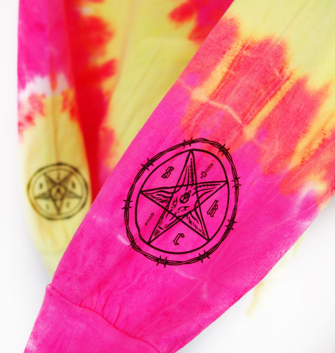 Close-up of tie-dye fabric in pink, yellow, and orange with black pentagram and barbed wire circle designs on the sleeves from Stay Sick Clothings Fluorescent Swirl collection.