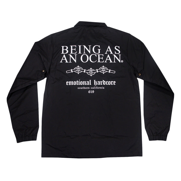 Black windbreaker jacket with white text on the back that reads, BEING AS AN OCEAN, emotional hardcore, southern california, 619, and a graphic of barbed wire.