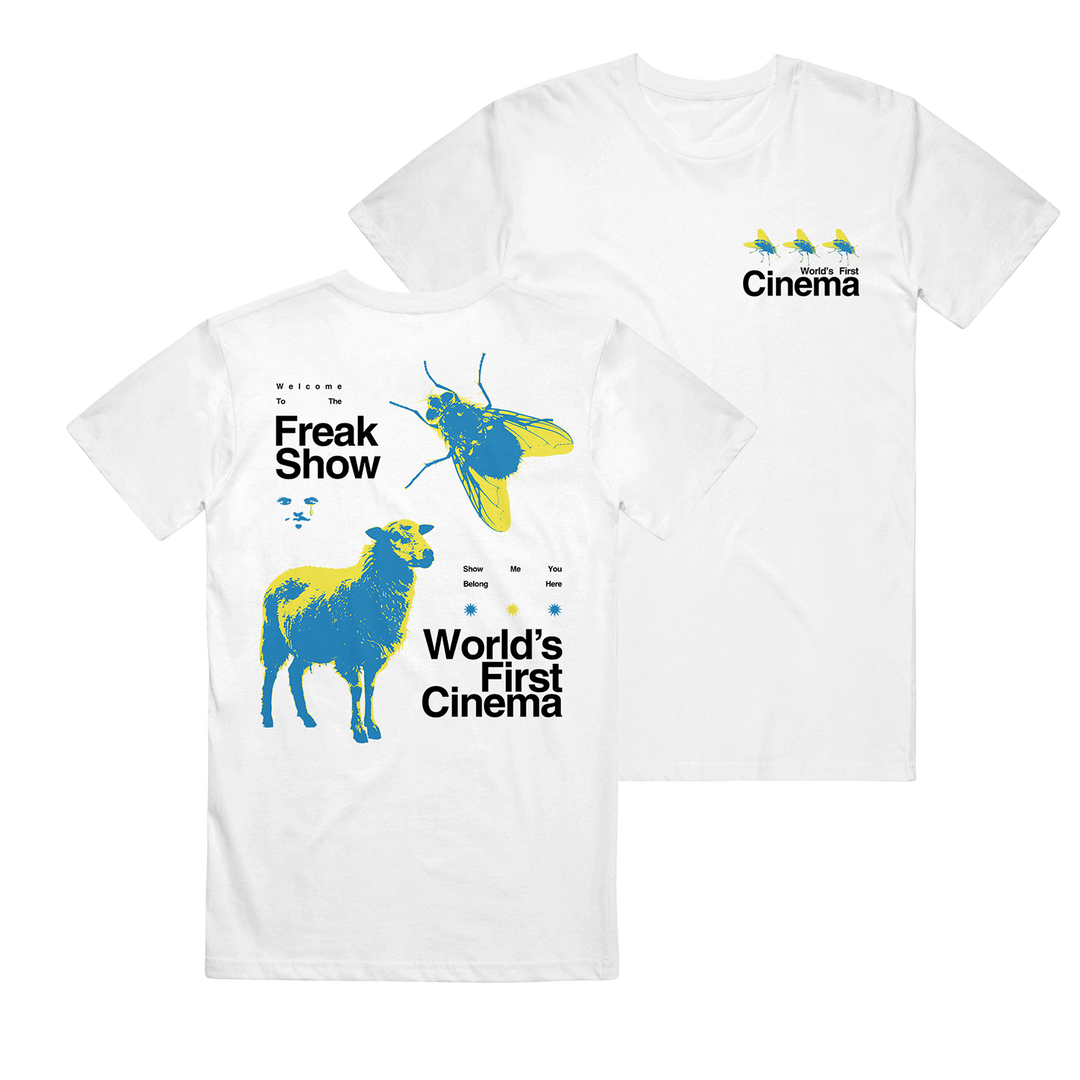 This World's First Cinema Comfort Colors tee features abstract blue/yellow sheep and beetle graphics on the back, three small birds on the front, and bold "Freak Show" and "World’s First Cinema" text.