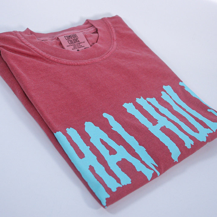 Folded brick t-shirt with blue shai hulud text on a white background