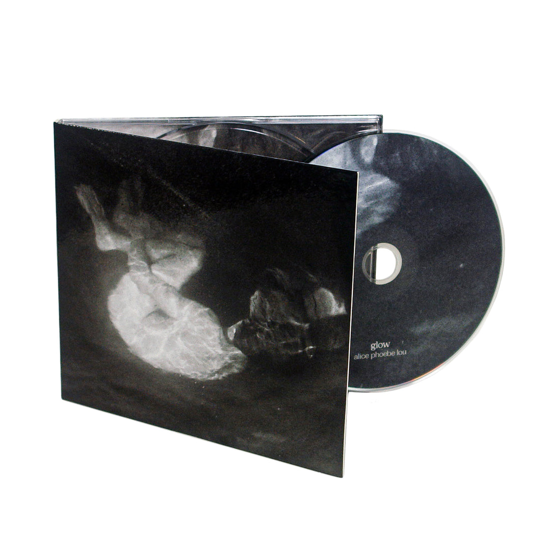 A CD partially removed from its case. The cover and CD feature a black and white abstract image. The CD is labeled glow Alice Phoebe Lou, marking her third album and a notable 2021 release.