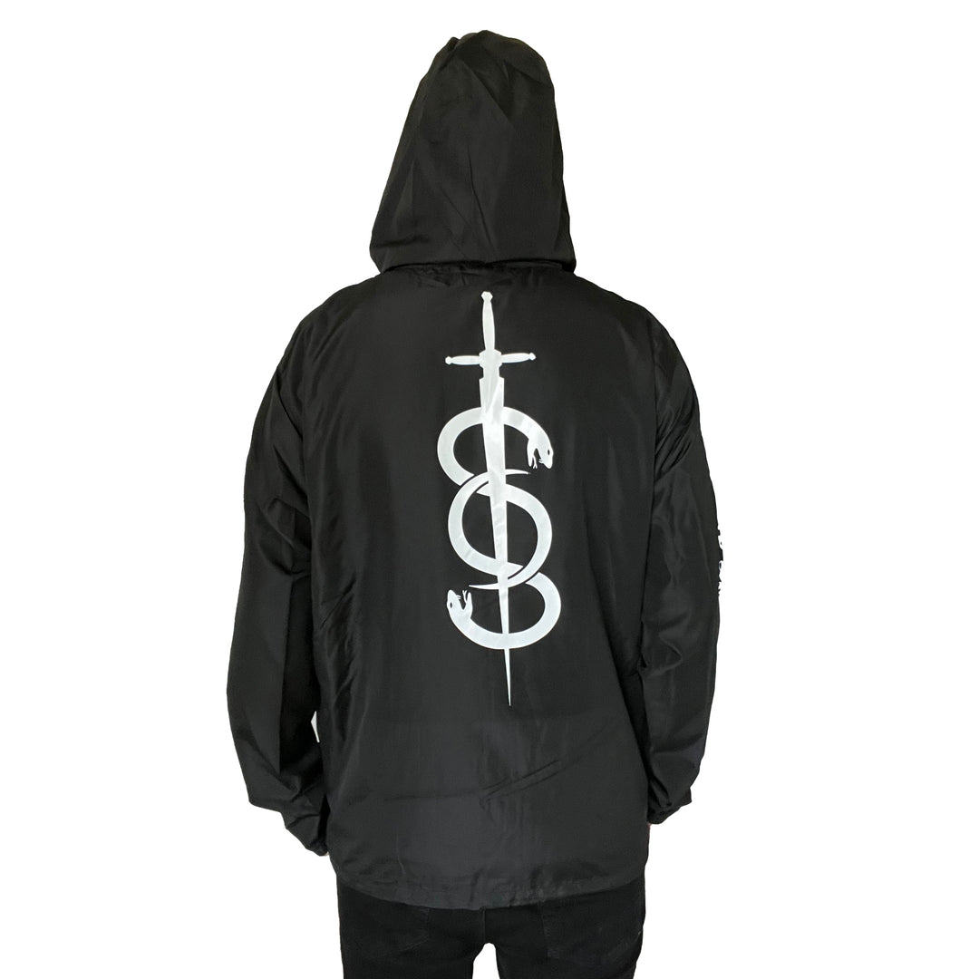 A person faces away from the camera against a white background, wearing a black Stay Sick Clothing zip-up jacket featuring a large white sword and snake graphic on the back.