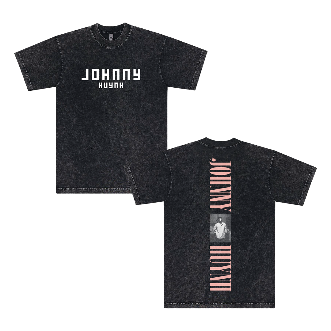 Front and back views of a black mineral wash unisex T-shirt by Johnny Huynh, with bold white JOHNNY HUYNH text on the front and a vertical pink JOHNNY HUYNH plus grayscale photo on the garment dye cotton back.