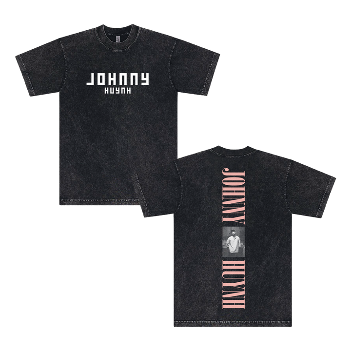Front and back views of a black mineral wash unisex T-shirt by Johnny Huynh, with bold white JOHNNY HUYNH text on the front and a vertical pink JOHNNY HUYNH plus grayscale photo on the garment dye cotton back.