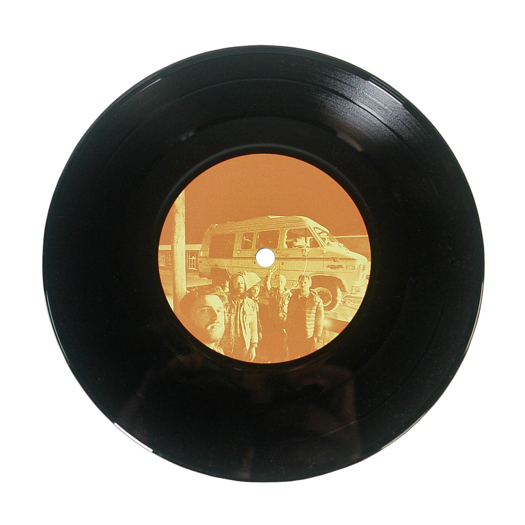 A black vinyl record with an orange label and a photo of people by a van—ideal for fans of alternative music and Sunbloc’s hardcore sound.