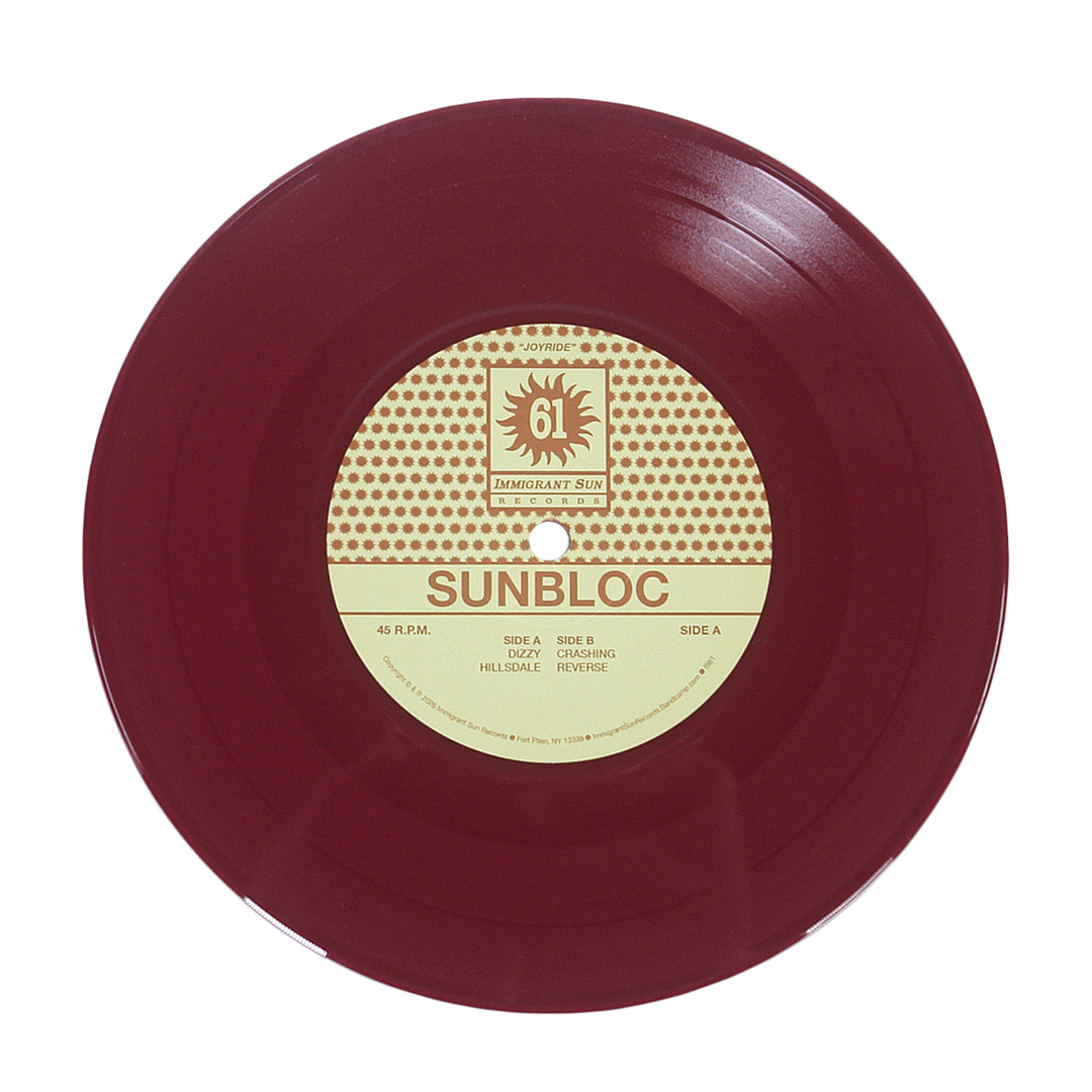 A maroon vinyl record with a cream and brown center label displays Sunbloc and track titles. Ideal for hardcore and alternative fans, the label features a sun logo with IMMIGRANT SUN RECORDS at the top. Brand: Sunbloc.