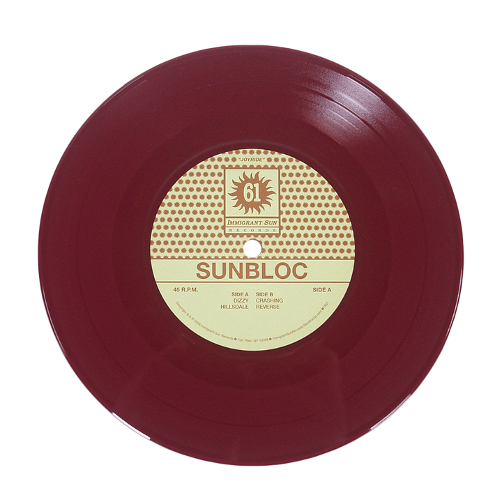 A maroon vinyl record with a cream and brown center label displays Sunbloc and track titles. Ideal for hardcore and alternative fans, the label features a sun logo with IMMIGRANT SUN RECORDS at the top. Brand: Sunbloc.