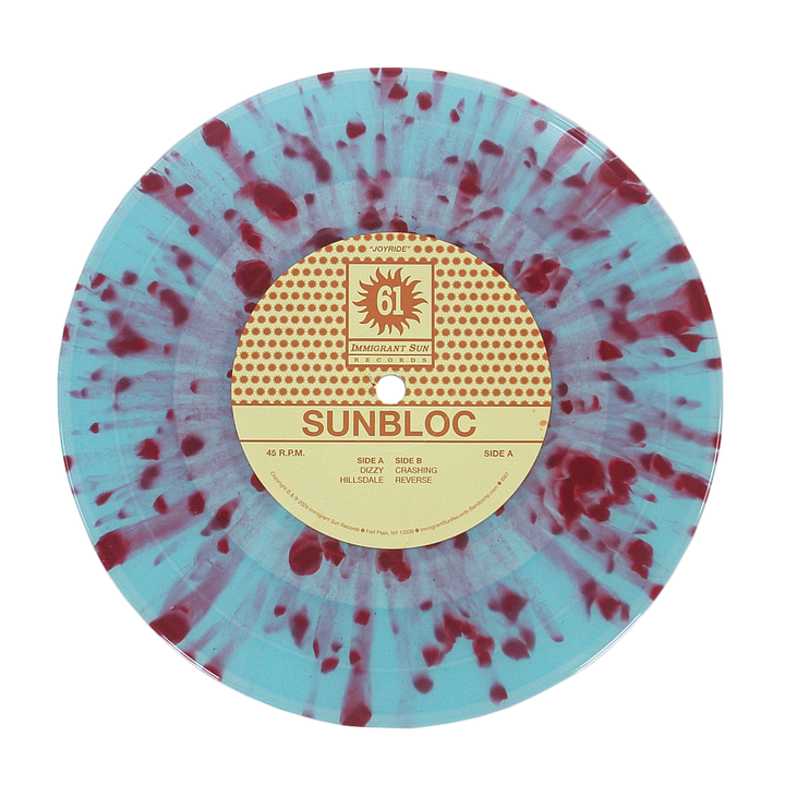 A light blue vinyl record with red splatter, featuring Sunbloc's Joyride EP info on a circular beige and red label—ideal for alternative music fans.