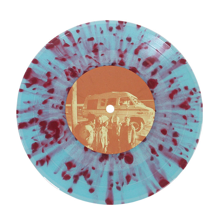 A vinyl record with a pale blue base and dark red splatter pattern. The center label shows a sepia photo of four people before a van, reflecting Sunbloc's alternative music vibe on the Joyride EP.