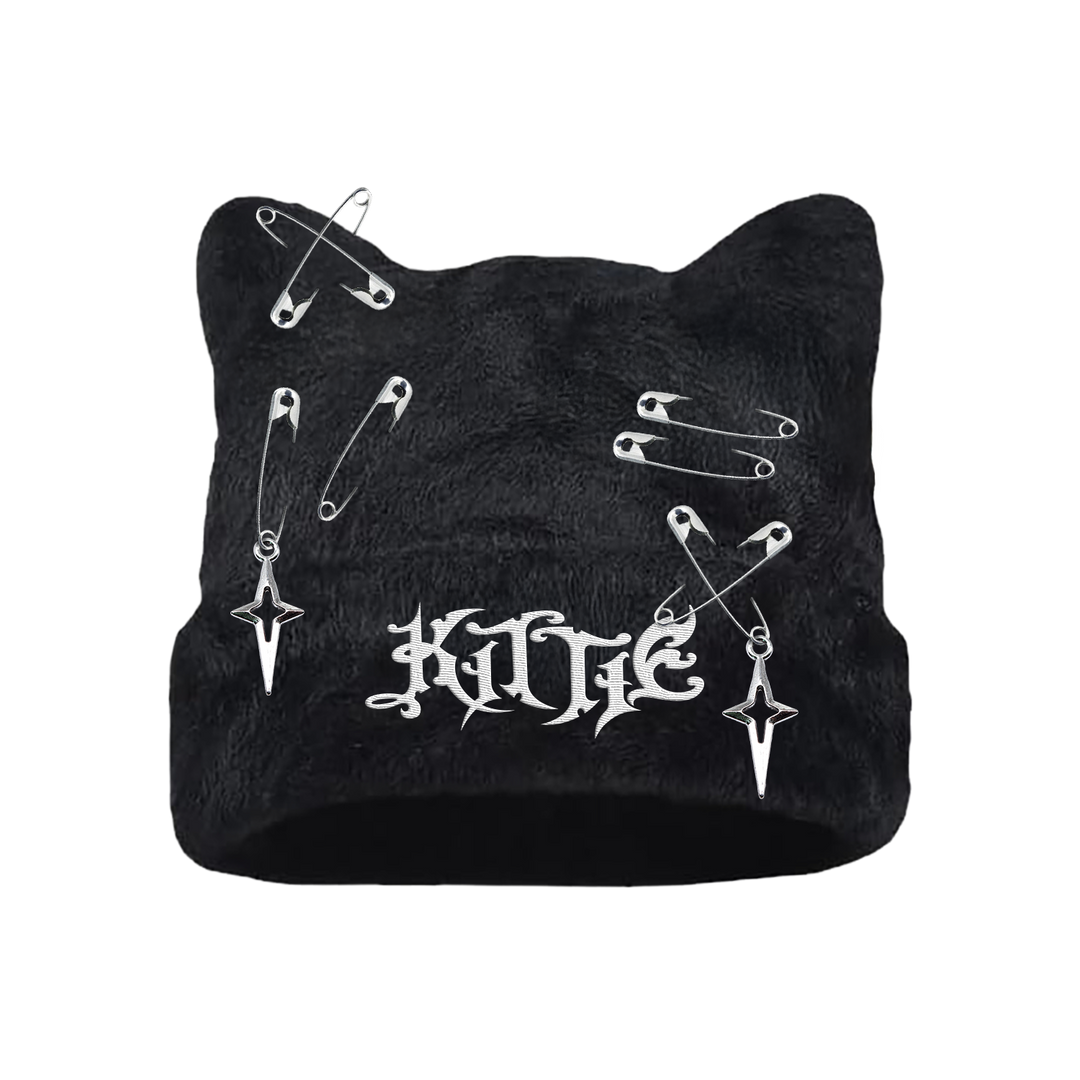 Kittie cat-ear winter beanie features a gothic white embroidered logo, silver safety pins, charms, and two dagger-shaped accents for a bold edge.