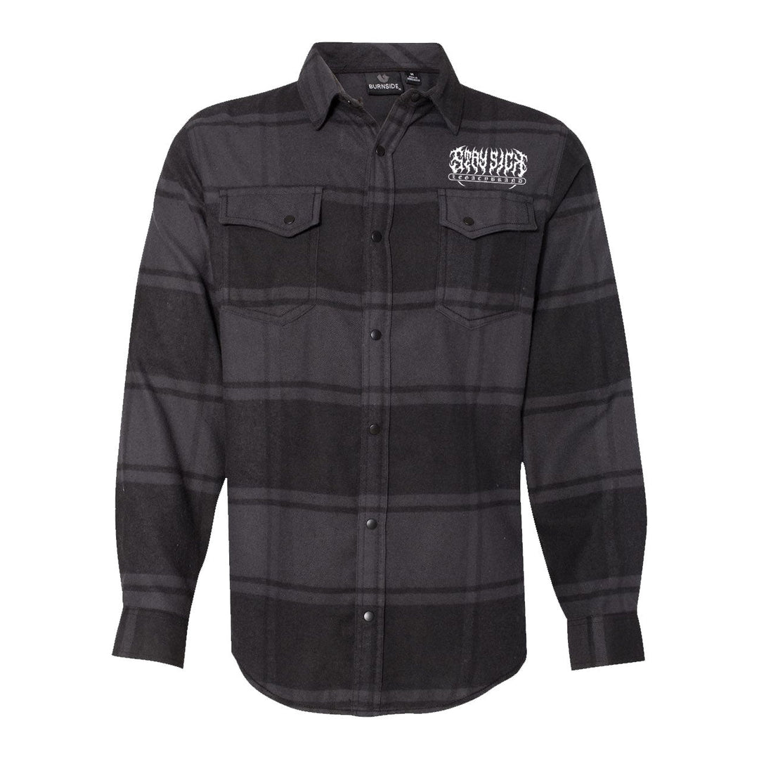 A black and dark gray plaid Stay Sick Clothing flannel shirt featuring long sleeves, two chest pockets, and a white graphic logo on the left chest.